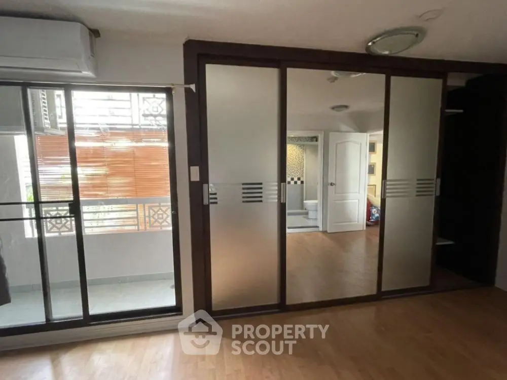 Spacious and well-lit corner unit with large sliding doors leading to a sunny balcony, featuring a seamless indoor-outdoor flow.