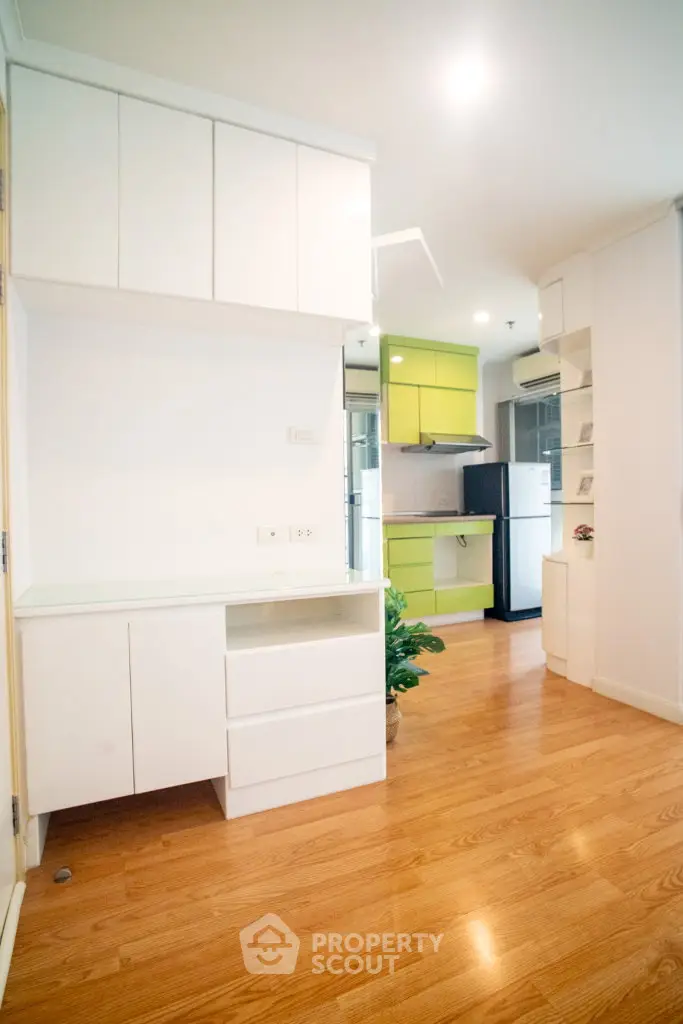 Modern kitchen with vibrant green cabinets and sleek white storage units