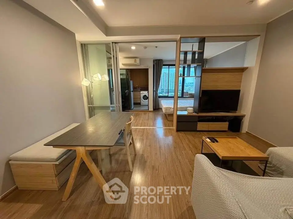 Modern living room with open layout, wooden flooring, and stylish furniture in a contemporary apartment.