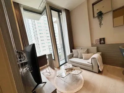 Modern living room with cozy sofa, large windows, and city view in high-rise apartment.