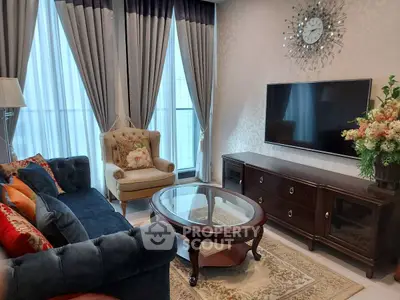 Elegant living room with plush sofa, stylish armchair, and large TV, perfect for relaxation.