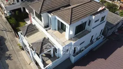 Stunning aerial view of a modern multi-level home with tiled roof and spacious balconies.