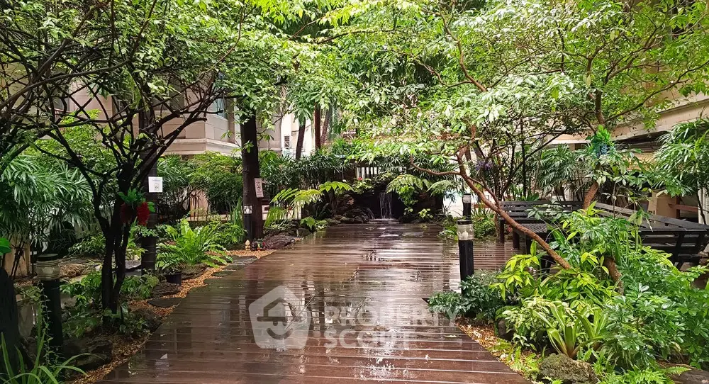 Lush garden pathway in luxury residential complex with vibrant greenery and serene ambiance.