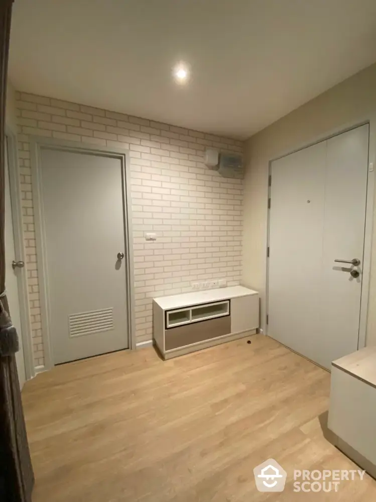 Modern apartment entrance with white brick wall and wooden flooring