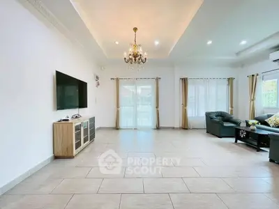 Spacious living room with elegant chandelier and modern furnishings