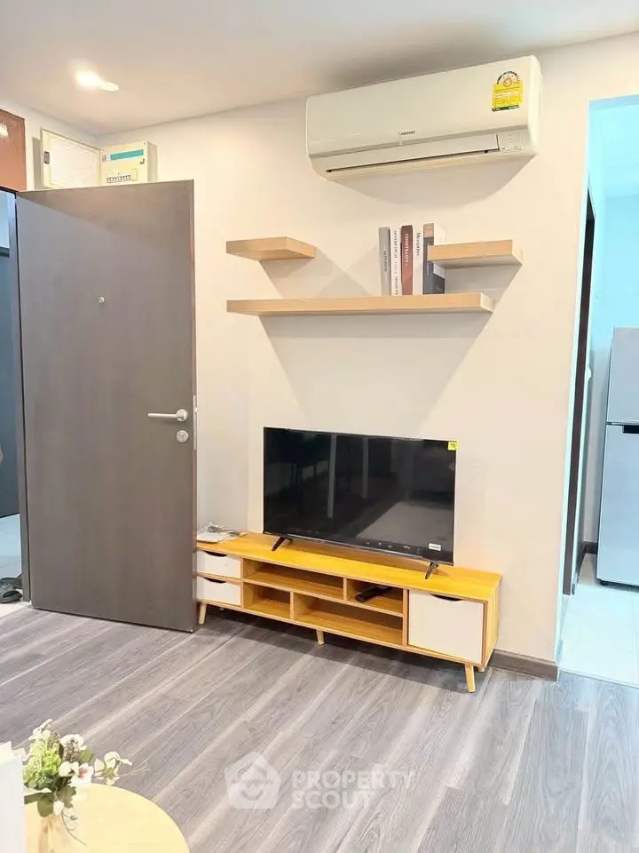 Modern living room with sleek TV stand, wall-mounted shelves, and air conditioning unit.