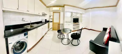 Spacious kitchen with modern appliances and cozy seating area in open layout.