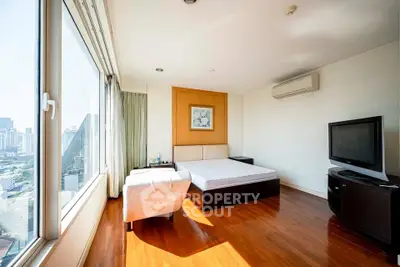 Spacious bedroom with city view, featuring modern furniture and large windows for natural light.