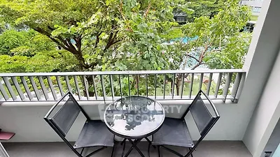 Charming balcony with lush garden view and cozy seating area.