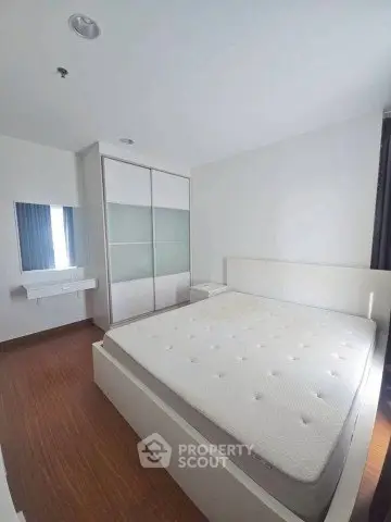 Modern bedroom with minimalist design featuring a large bed and built-in wardrobe.