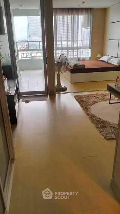 Modern studio apartment with balcony and city view, featuring cozy bedroom and stylish decor.