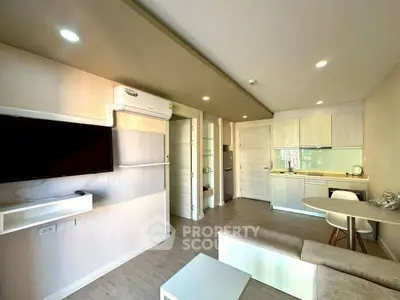 Modern open-plan living room with kitchen, featuring sleek design and neutral tones.