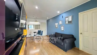 Stylish living room with modern decor and open layout, featuring a cozy sofa and wall-mounted TV.