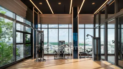 Luxurious high-rise gym with panoramic city views and modern fitness equipment.