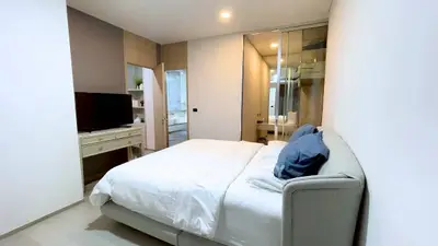Modern bedroom with sleek design, featuring a cozy bed, built-in wardrobe, and stylish decor.