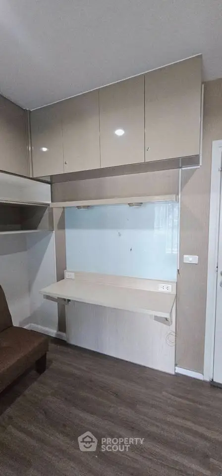 Modern study area with built-in desk and cabinets in a stylish apartment.
