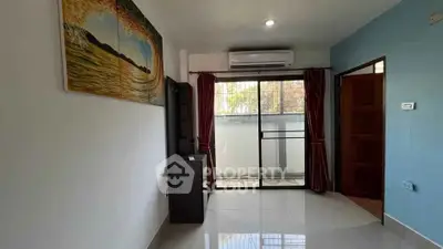 Bright living room with balcony access and air conditioning, featuring modern decor and natural light.