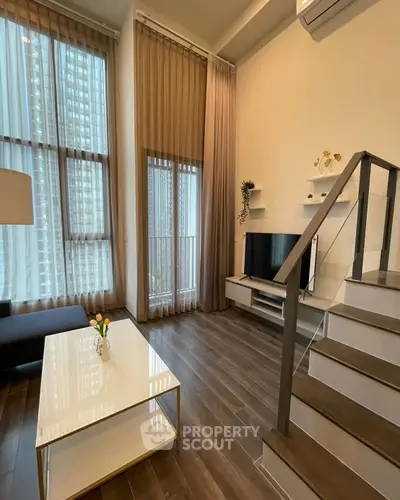 Modern living room with high ceilings and stylish decor in a luxury apartment.