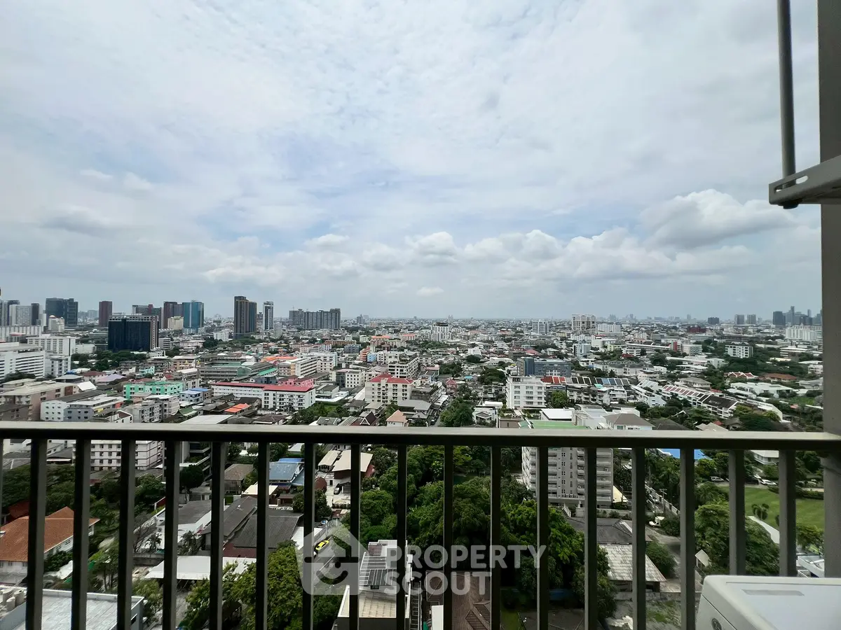 Stunning cityscape view from a high-rise balcony showcasing urban skyline and lush greenery.