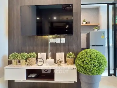 Modern living room with wall-mounted TV and stylish decor in a cozy apartment.