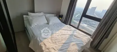 Modern bedroom with large window offering city view and natural light