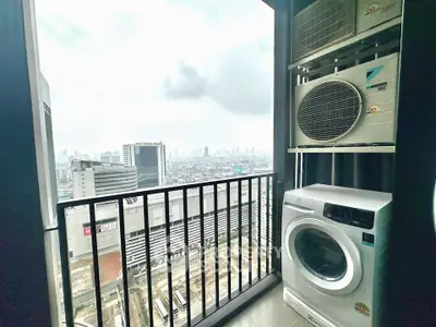 High-rise apartment balcony with city view and laundry appliances, perfect for urban living.