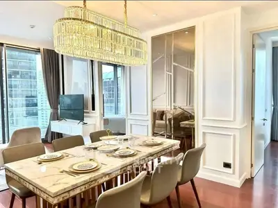Luxurious dining area with elegant chandelier and marble table in modern apartment.