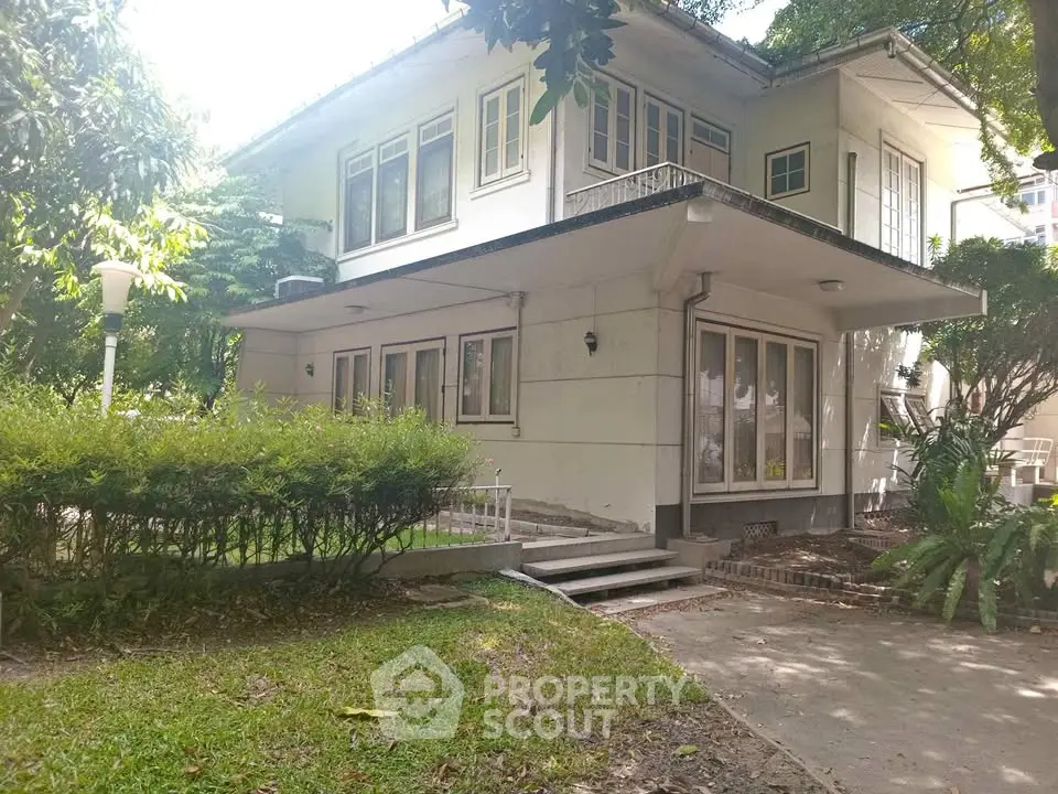 Charming two-story house with lush garden and spacious outdoor area.