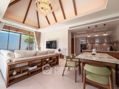 Luxurious open-plan living room with high ceilings and modern kitchen in elegant home.