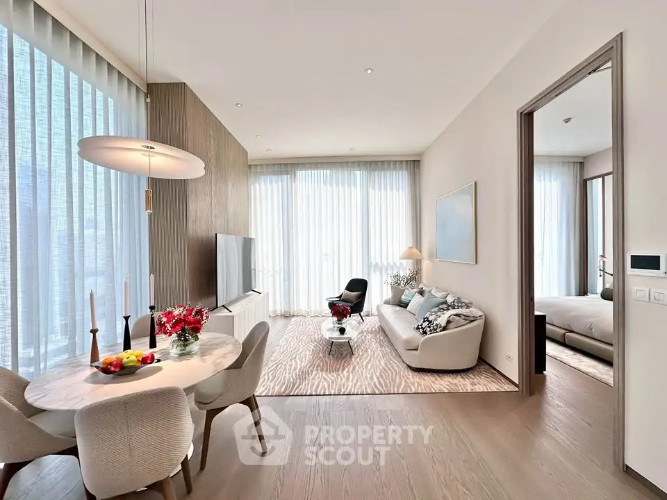 Modern open-plan living room with elegant dining area and cozy seating, featuring floor-to-ceiling windows.