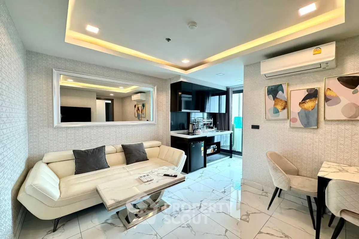 Modern living room with elegant decor and open kitchen layout, featuring sleek furniture and stylish lighting.