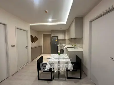 Modern kitchen with dining area, featuring sleek cabinetry and contemporary design.