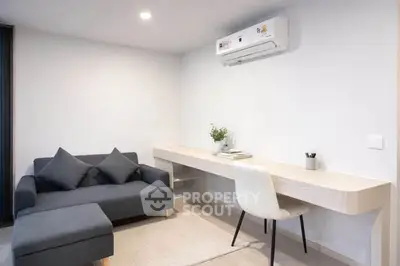 Modern living room with sleek furniture and built-in desk, perfect for work and relaxation.
