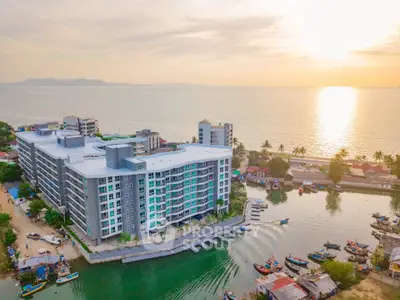 Stunning waterfront apartment building with breathtaking ocean views at sunset.