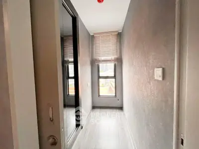 Modern hallway with sleek flooring and large window, perfect for natural light.