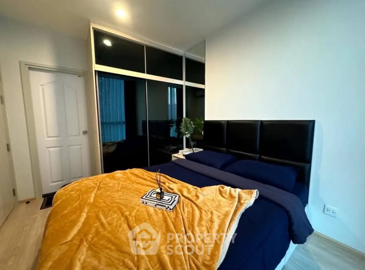 Modern bedroom with stylish decor and mirrored wardrobe in a cozy apartment.