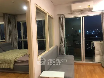 Modern apartment interior with city view, featuring a cozy living area and bedroom with large windows.