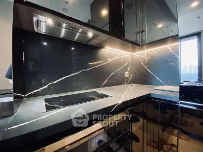Luxurious modern kitchen with sleek black marble countertops and built-in oven, perfect for gourmet cooking.