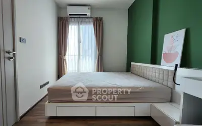 Modern bedroom with green accent wall and large window for natural light