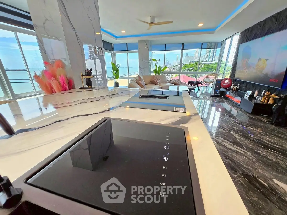 Luxurious modern living room with panoramic city view and sleek marble countertops.