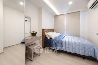 Modern bedroom with sleek design, featuring a cozy bed, stylish mirror, and elegant lighting.