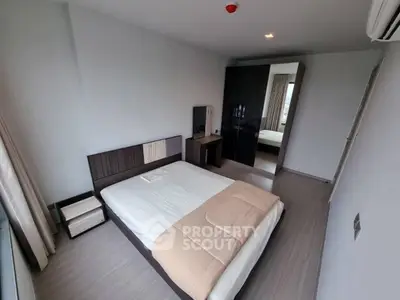 Modern bedroom with sleek design and ample natural light, featuring a stylish bed and wardrobe.