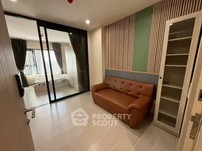 Modern apartment interior with stylish living room and bedroom separation, featuring sleek furniture and natural light.
