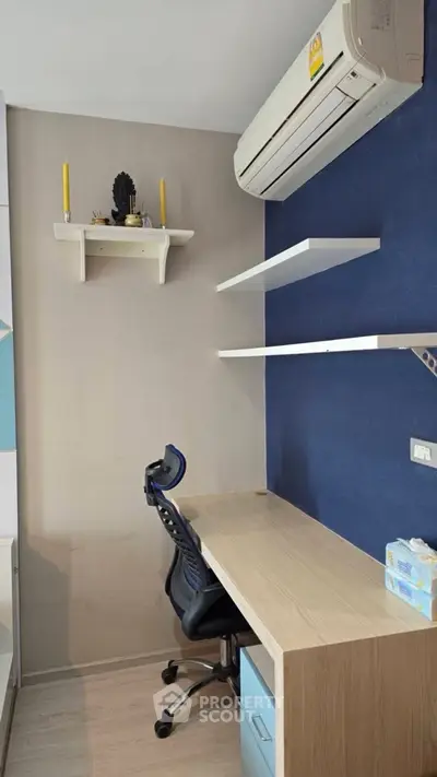 Modern study room with desk, shelves, and air conditioning in a stylish apartment.