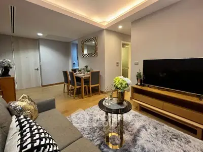 Modern living room with stylish decor and dining area, featuring cozy seating and elegant lighting.