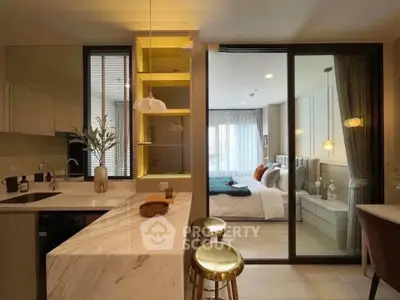 Modern open-layout kitchen with marble island and view into cozy bedroom