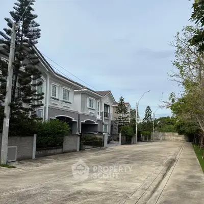 Elegant suburban street with modern townhouses and lush greenery