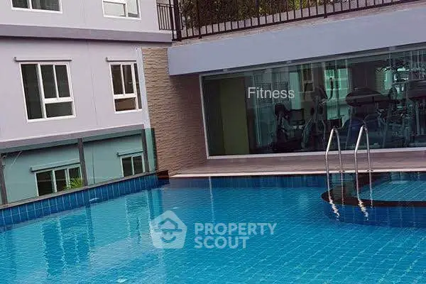 Modern apartment building with pool and fitness center view.