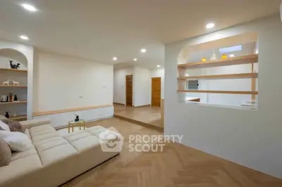 Spacious modern living room with elegant wooden flooring and cozy seating area.