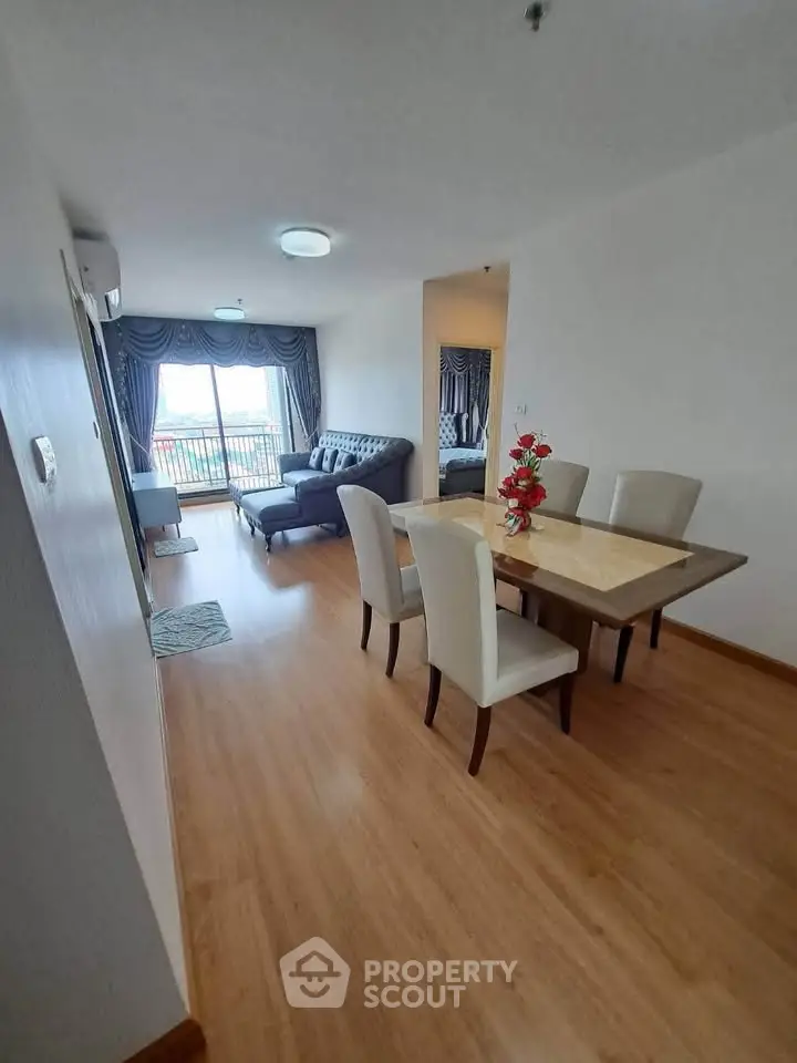 Spacious living room with elegant dining area and balcony view in modern apartment.